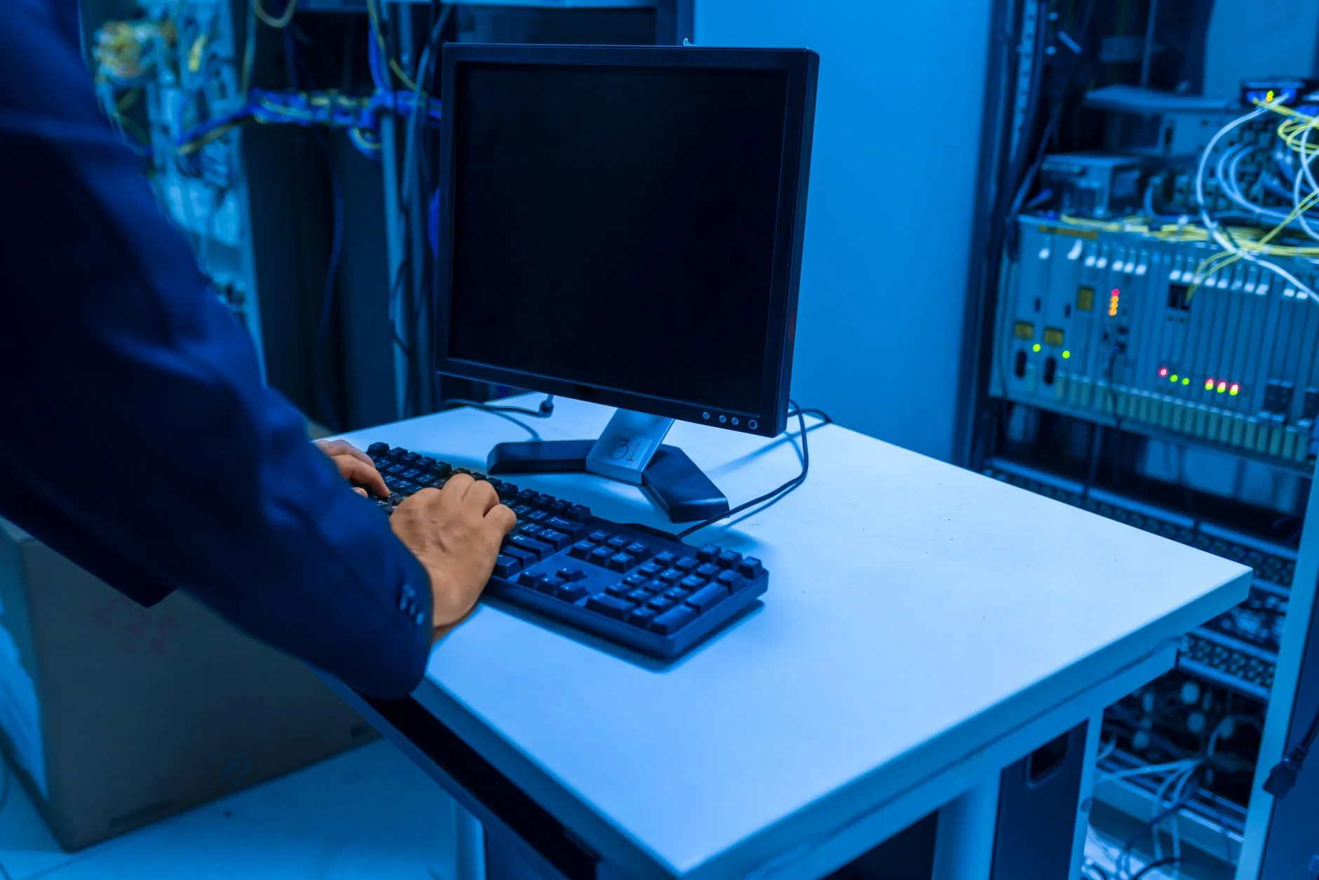 Server room with cybersecurity hardware under LED lights, showcasing top 2024 solutions.